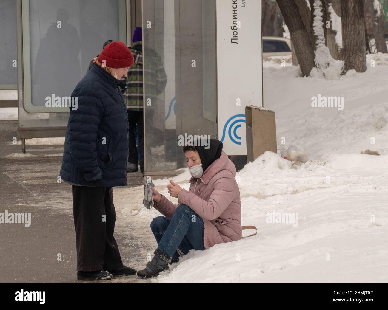 Im Winter 2022 sitzt eine Frau im Schnee Stockfoto