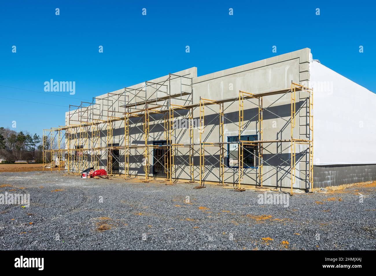 Horizontal abgewinkelte Aufnahme eines neuen Einzelhandelsbaus mit Gerüsten an der Vorderseite. Stockfoto