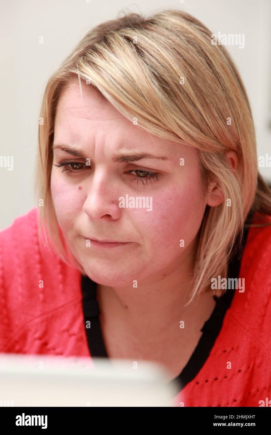 Eine junge Frau, die von zu Hause aus auf ihrem Laptop arbeitet. Stockfoto