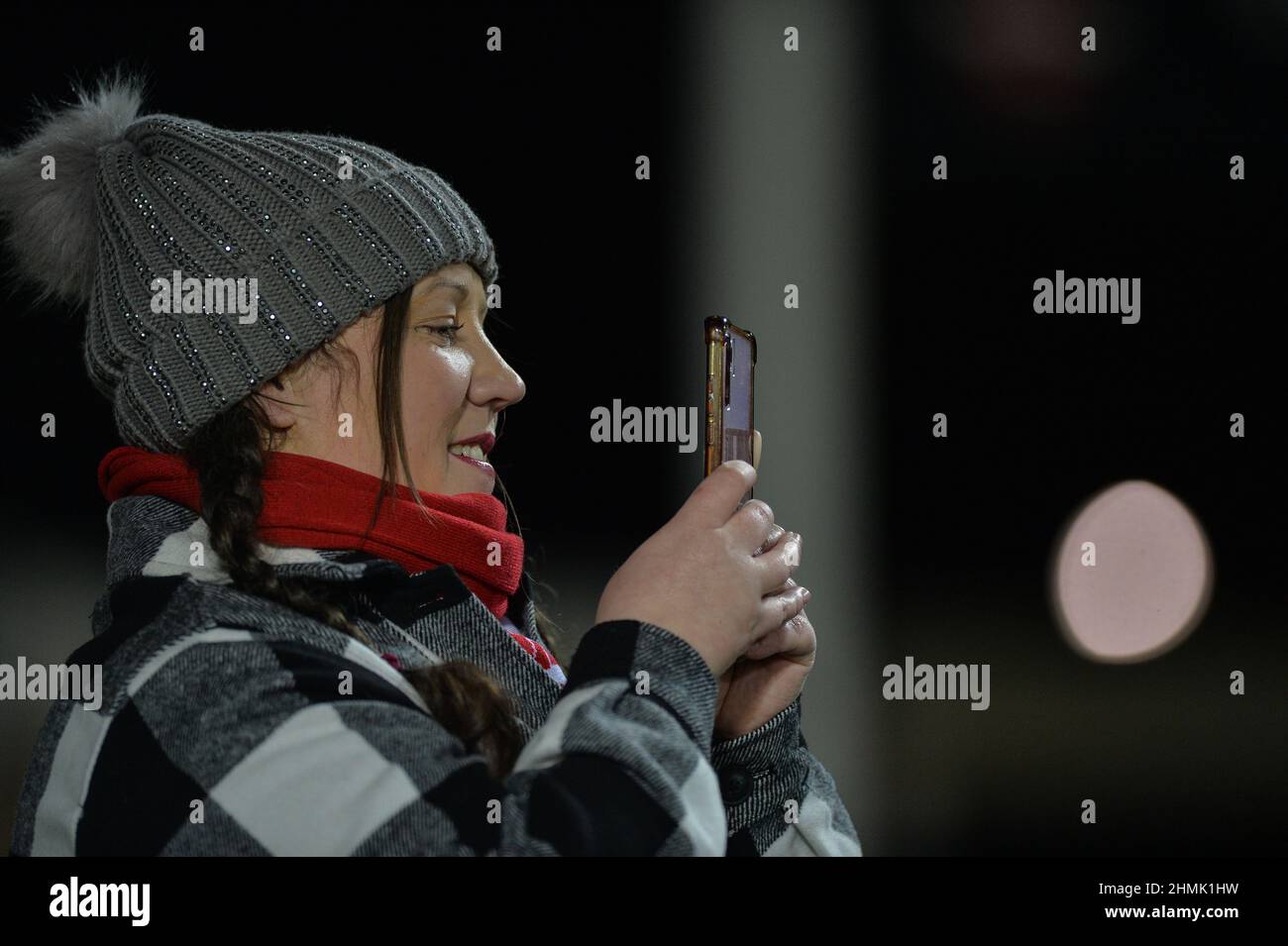 St. Helens, England - 10. Februar 2022 - Eine St.Helens-Fan nimmt die Ereignisse vor der Rugby League Betfred Super League Runde 1 St. Helens vs Catalan Dragons im Totally Wicked Stadium, St. Helens, UK Dean Williams, auf ihrem Handy auf Stockfoto