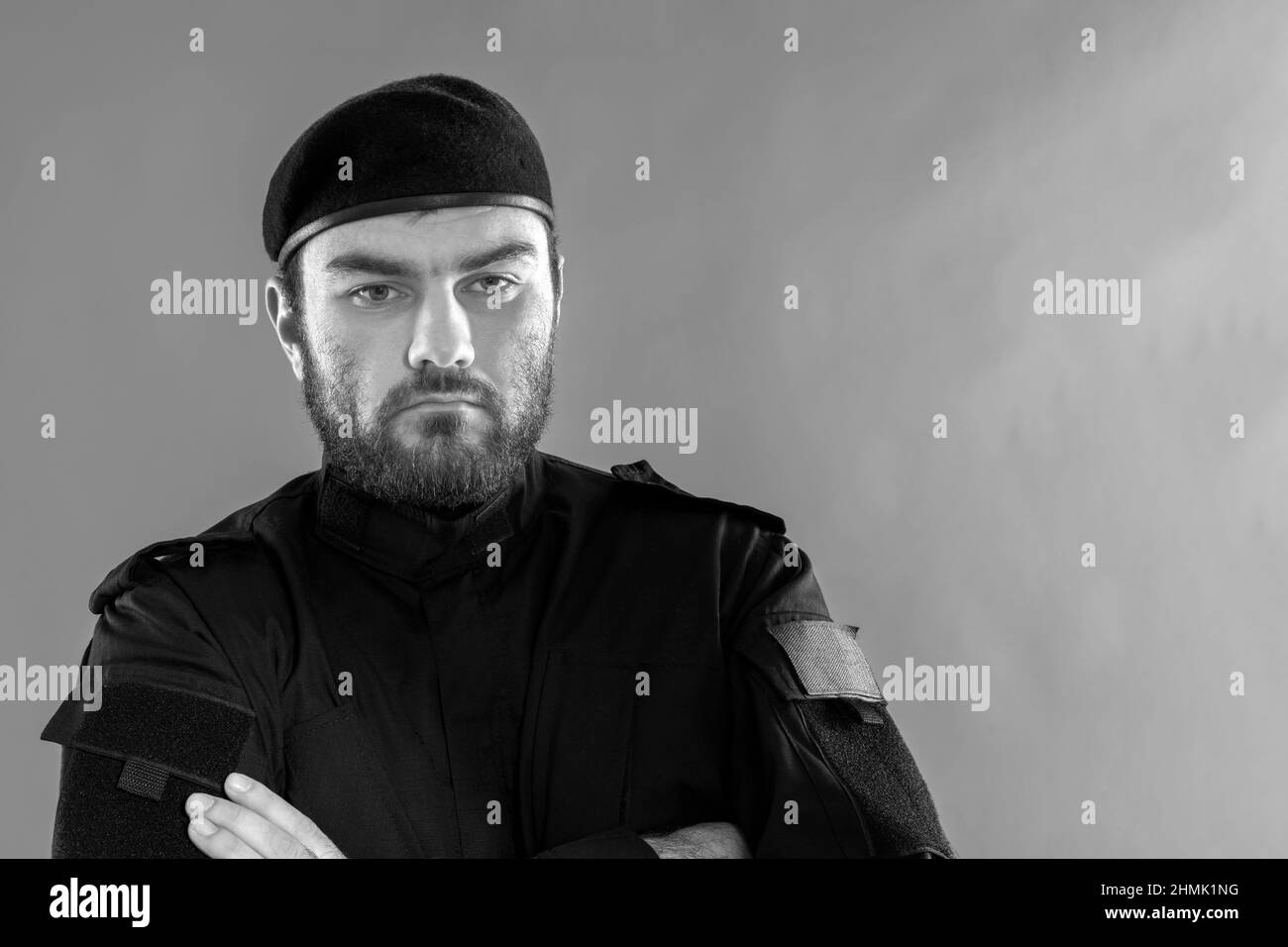 Bodyguard. Polizeibeamter mit einem strengen Blick. Ein männlicher Sicherheitsmann in schwarzer Uniform und eine Mütze mit einem ernsthaften, imposanten Look. Söldner. Mil Stockfoto