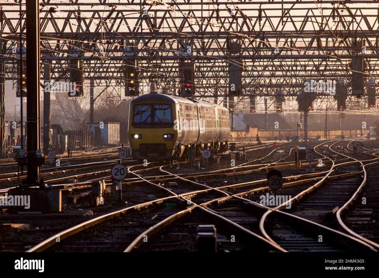 Der Zug der Northern Rail der Klasse 323, der in der aufgehenden Sonne glitzert, überquert eine Eisenbahnknotenpunkt im Manchester Picadilly Bahnhof Stockfoto