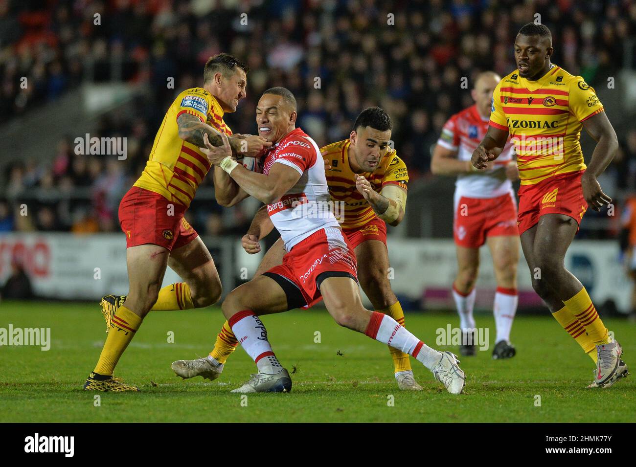 St. Helens, England - 10. Februar 2022 - will Hopoate von St. Helens greift während der Rugby League Betfred Super League Runde 1 St. Helens gegen Catalan Dragons im Totally Wicked Stadium, St. Helens, UK Dean Williams, die Linie der katalanischen Drachen an Stockfoto