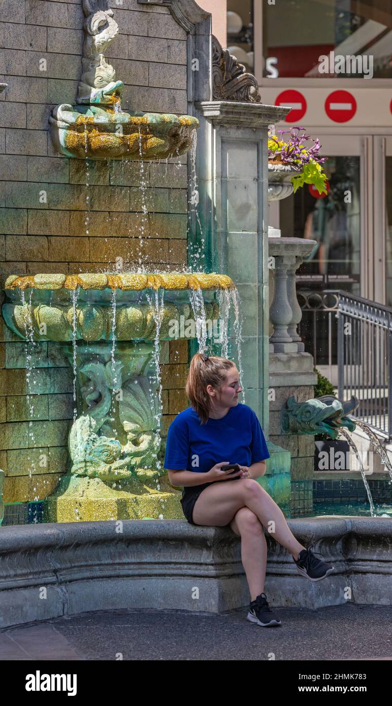 Junges Mädchen genießen Sommertag entspannen durch Stadtbrunnen. Stockfoto