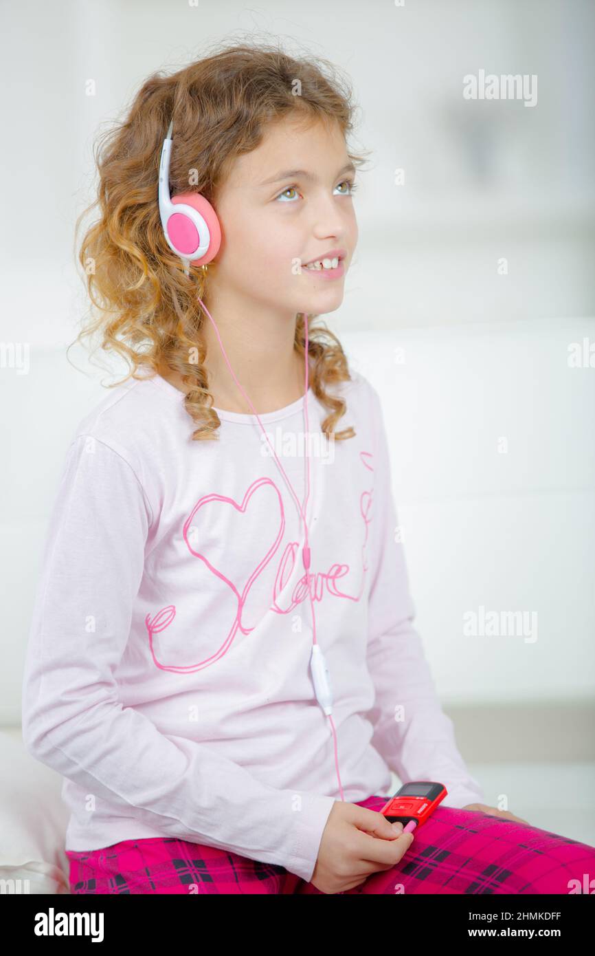 Ein Schulmädchen, das Kopfhörer hört Stockfoto