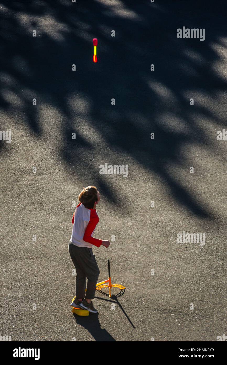 Der neunjährige Junge beobachtet eine Plastikrakete, die er auf dem Bürgersteig des Wohngebiets Castle Rock Colorado USA in die Luft geschossen hat. Foto aufgenommen im Dezember. Stockfoto