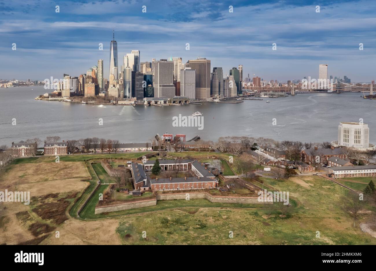 Luftaufnahme des historischen Backsteins Fort Jay auf Governors Island, der den Hudson River in New York bewacht, mit Blick auf die Wolkenkratzer des Finanzdistr Stockfoto