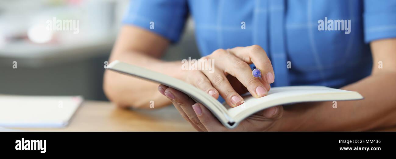 Frau hält Stift und Tagebuch unserer Dokumente mit Diagrammen Nahaufnahme Stockfoto