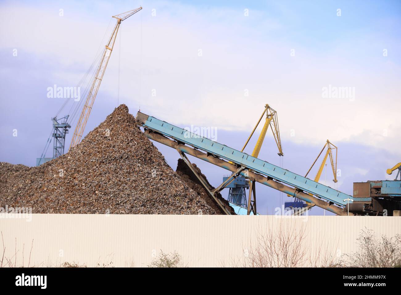 Metall wird in einer Recyclinganlage an den Docks in Belfast, Nordirland, komprimiert und zerkleinert, wo es für den Export vorbereitet wird. Stockfoto