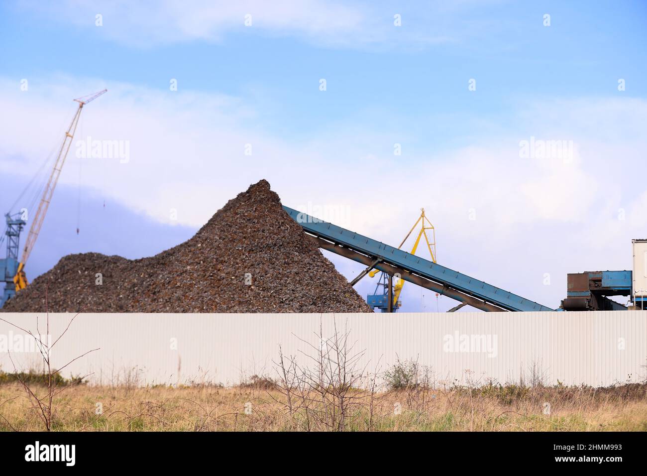 Metall wird in einer Recyclinganlage an den Docks in Belfast, Nordirland, komprimiert und zerkleinert, wo es für den Export vorbereitet wird. Stockfoto