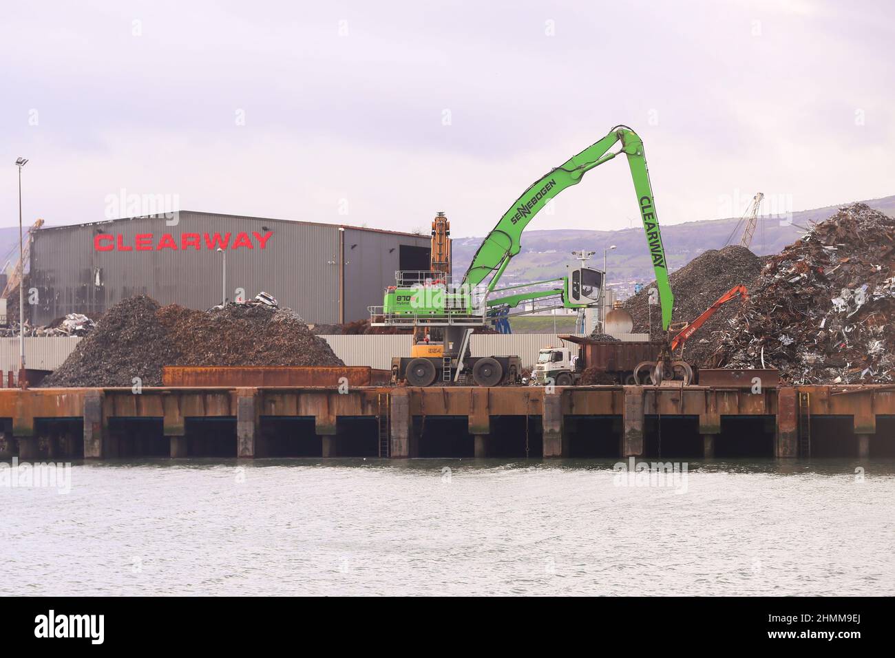 Metall wird in einer Recyclinganlage an den Docks in Belfast, Nordirland, komprimiert und zerkleinert, wo es für den Export vorbereitet wird. Stockfoto