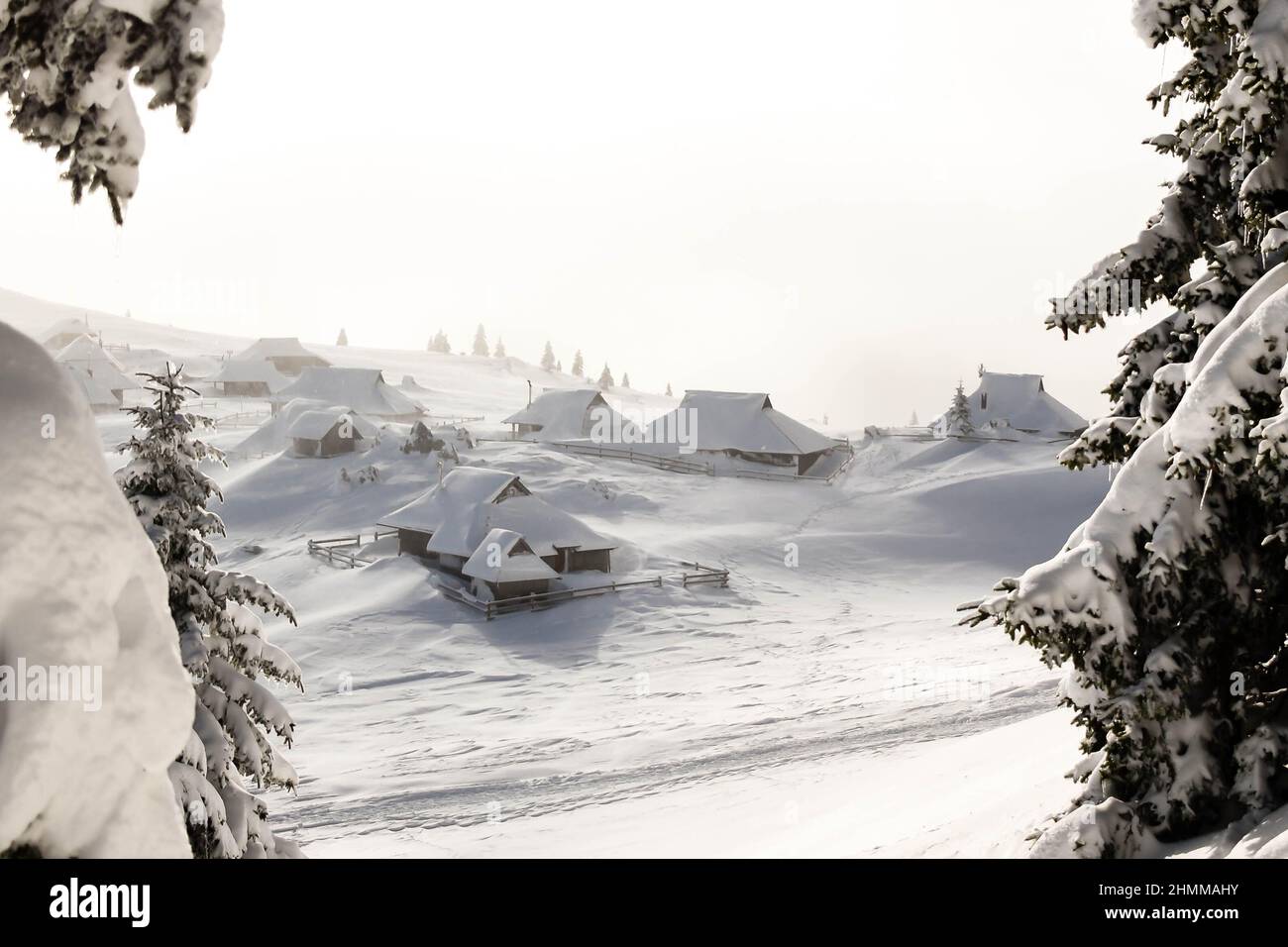 Das Bergdorf Mala planina ist im Winter mit Schnee bedeckt. Der Schneesturm ist in der Nähe und treibt den Schnee durch starke Winde. Stockfoto