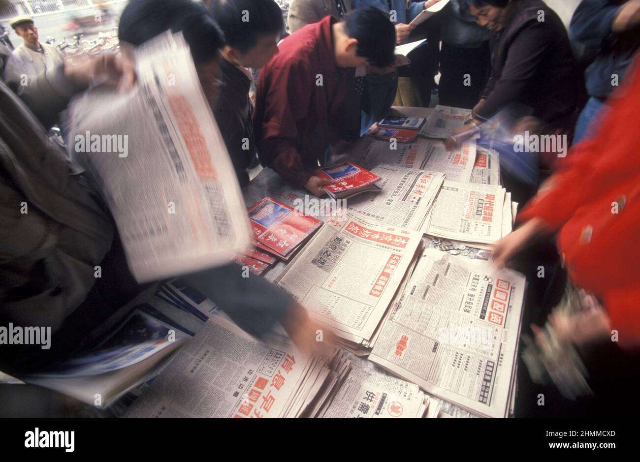 Menschen mit Zeitungen auf dem Aktienmarkt in der Stadt Nanchang in der Provinz Jiangxi in China. China, Nanchang, November 1996 Stockfoto