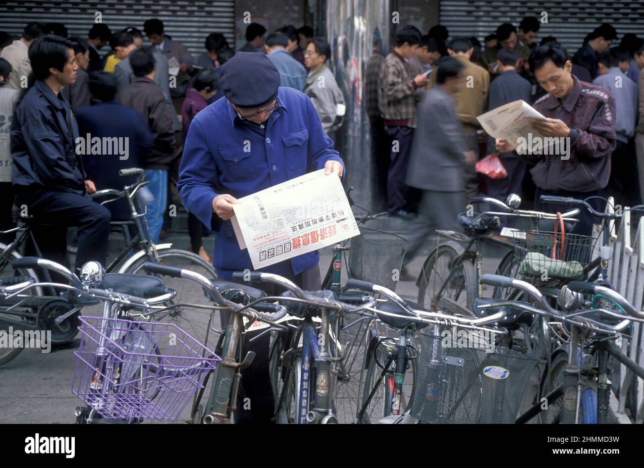 Menschen mit Zeitungen im Stockmerket in der Stadt Nanchang in der Provinz Jiangxi in China. China, Nanchang, November 1996 Stockfoto