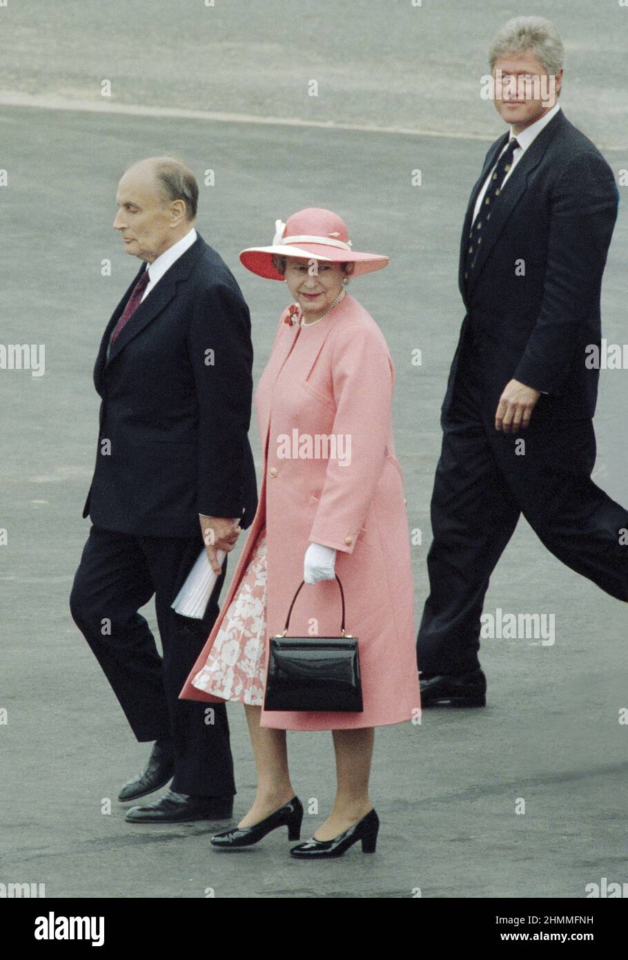 Omaha Beach, 50th. Jahrestag der D-Day Landings (Normandie, Nordwestfrankreich), 1994/06/06: Königin Elizabeth II. Trägt ein pinkes Outfit mit passendem Hut anlässlich der internationalen Zeremonie. Hier, begrüßt vom französischen Präsidenten Francois Mitterrand und Bill Clinton, dem Präsidenten der Vereinigten Staaten Stockfoto