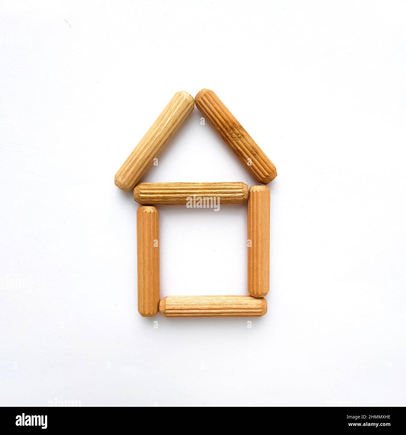 Haus aus Holzstäben auf weißem Hintergrund. Einfache Form Stockfoto