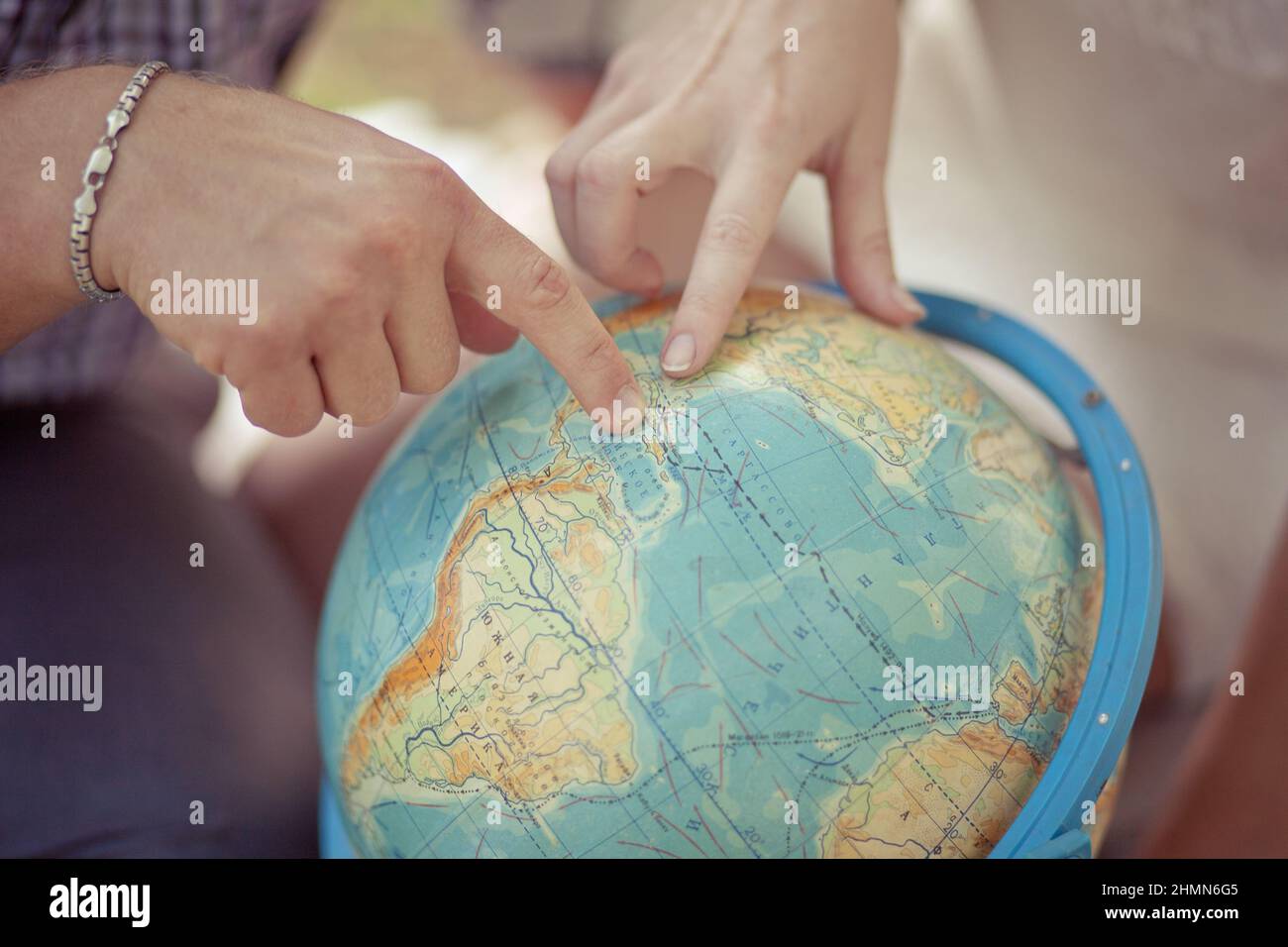 Frau und Geschäftsmann mit Weltkarte Schnittstelle zeigen zu Globus. Planet Erde Globus. Draufsicht auf Amerika. Reisekonzept. Feiertage. Ein junges Paar ist Stockfoto