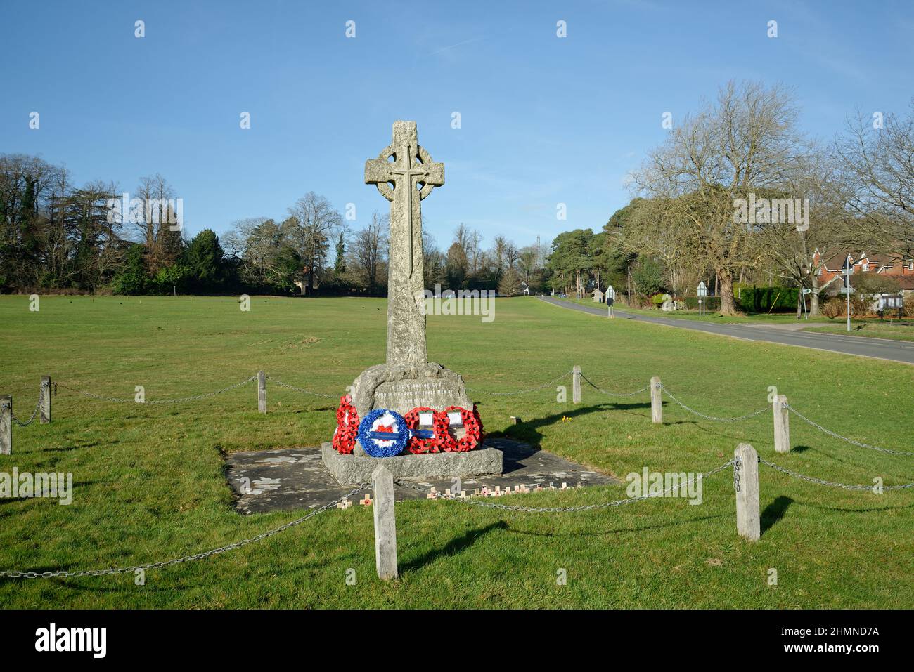 War Memorial bei Staplefield Green in West Sussex. Ein christliches Kreuz mit Mohnkränzen unten. Stockfoto