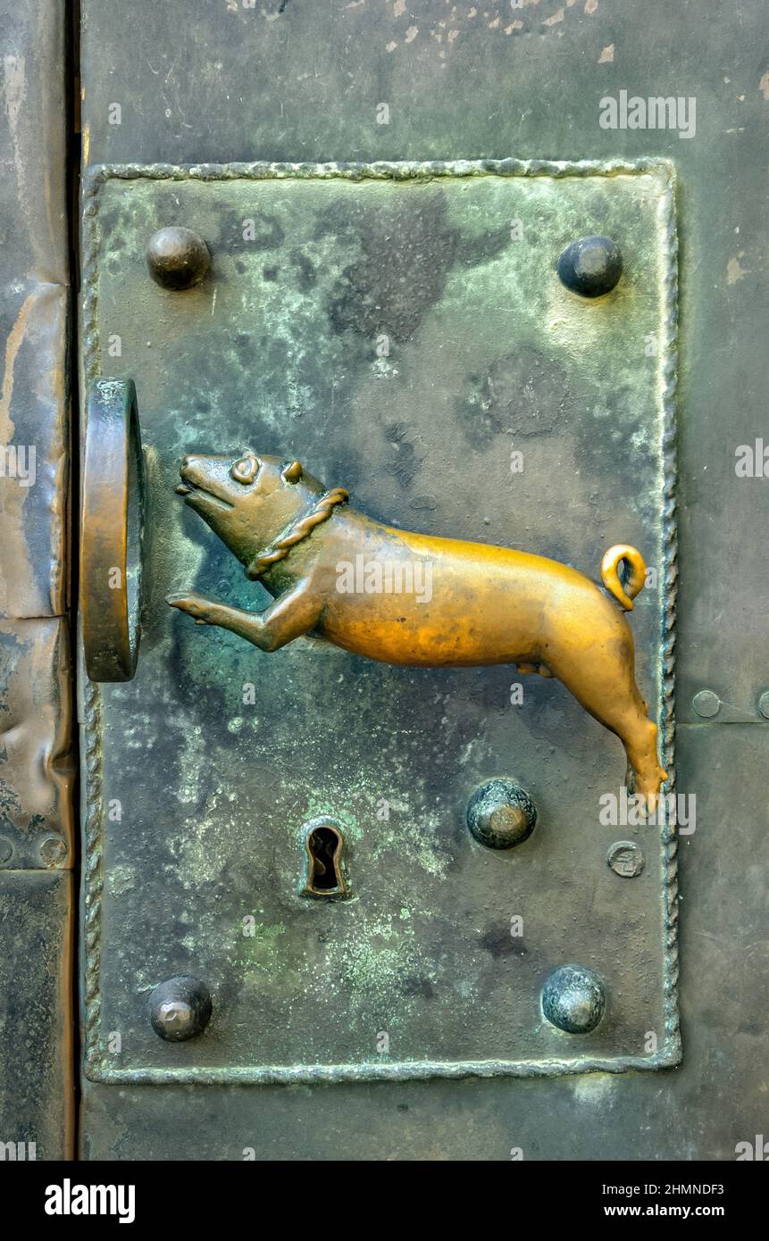 Türgriff, der 1970s vom Bildhauer Heinrich Apel geschaffen wurde, entworfen als ein Schweinehund, der durch einen Ring springt, am Quedlinburger Dom. Stockfoto
