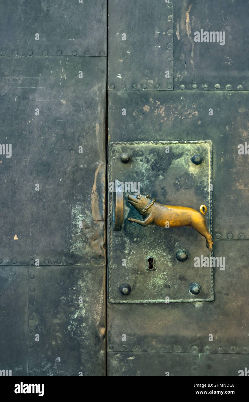 Türgriff, der 1970s vom Bildhauer Heinrich Apel geschaffen wurde, entworfen als ein Schweinehund, der durch einen Ring springt, am Quedlinburger Dom. Stockfoto