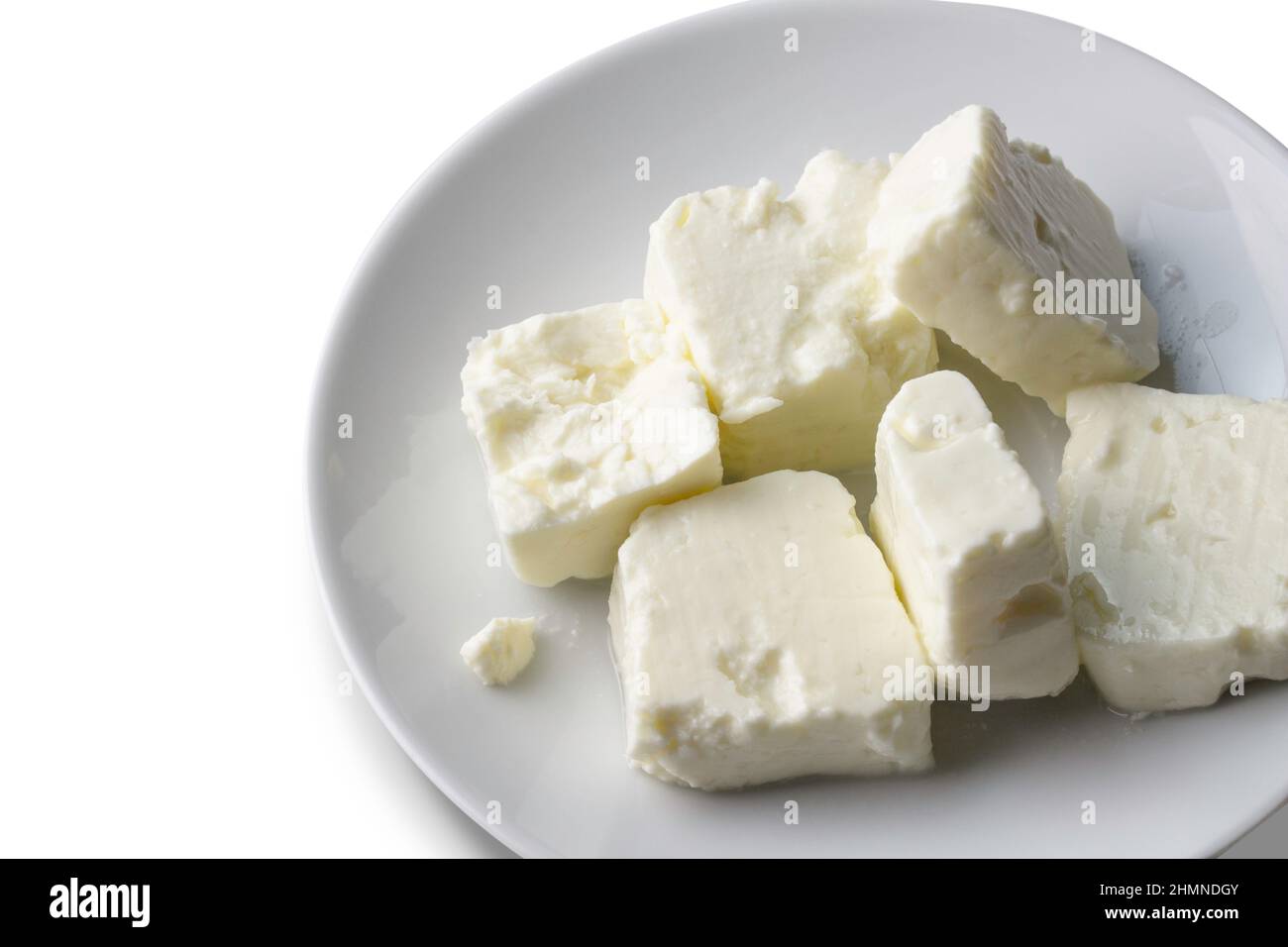 Teller mit weichem weißem Käse auf weißem Hintergrund - Feta-Würfel Stockfoto