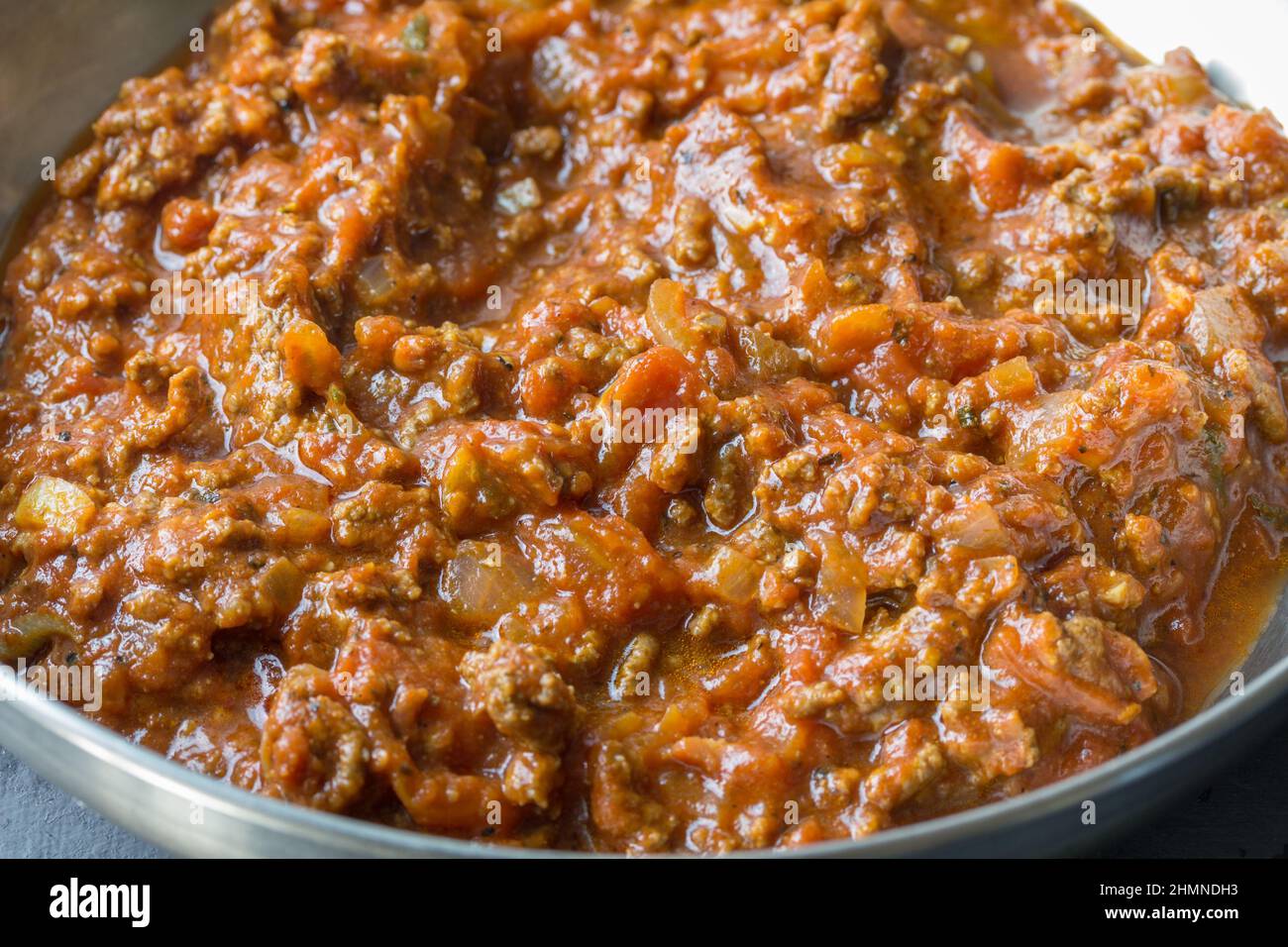 Food-Fotografie einer italienischen Bolognese-Fleisch-Pasta-Sauce in einer Edelstahlpfanne - Nahaufnahme Stockfoto