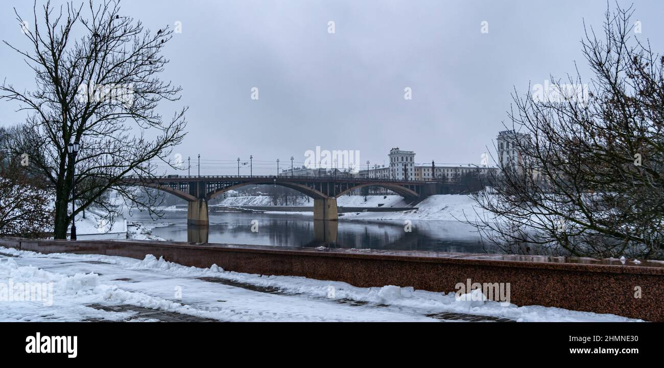 Vitebsk, Weißrussland - Februar 2022: Ufer des westlichen Flusses Dwina mit Blick auf die Kirowski-Brücke. Horizontales Foto. Stockfoto