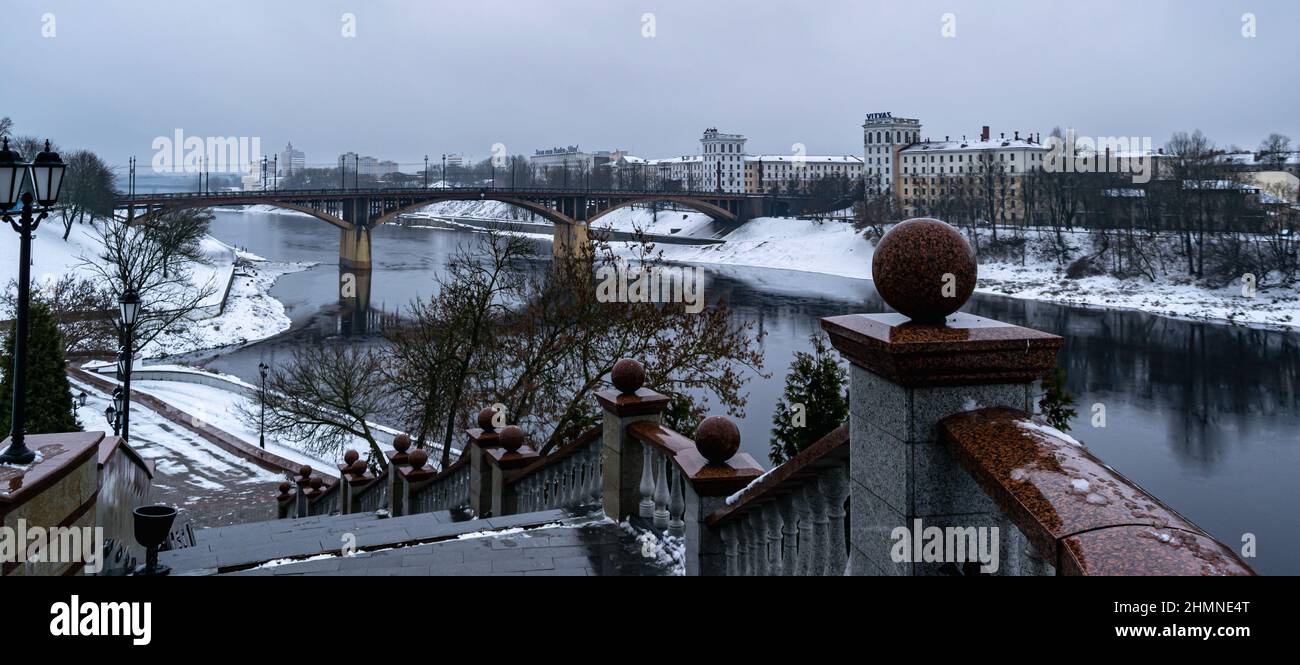 Vitebsk, Weißrussland - Februar 2022: Blick vom Berg Mariä Himmelfahrt auf das westliche Ufer des Flusses Dwina und die Kirowski-Brücke. Horizontales Foto. Stockfoto