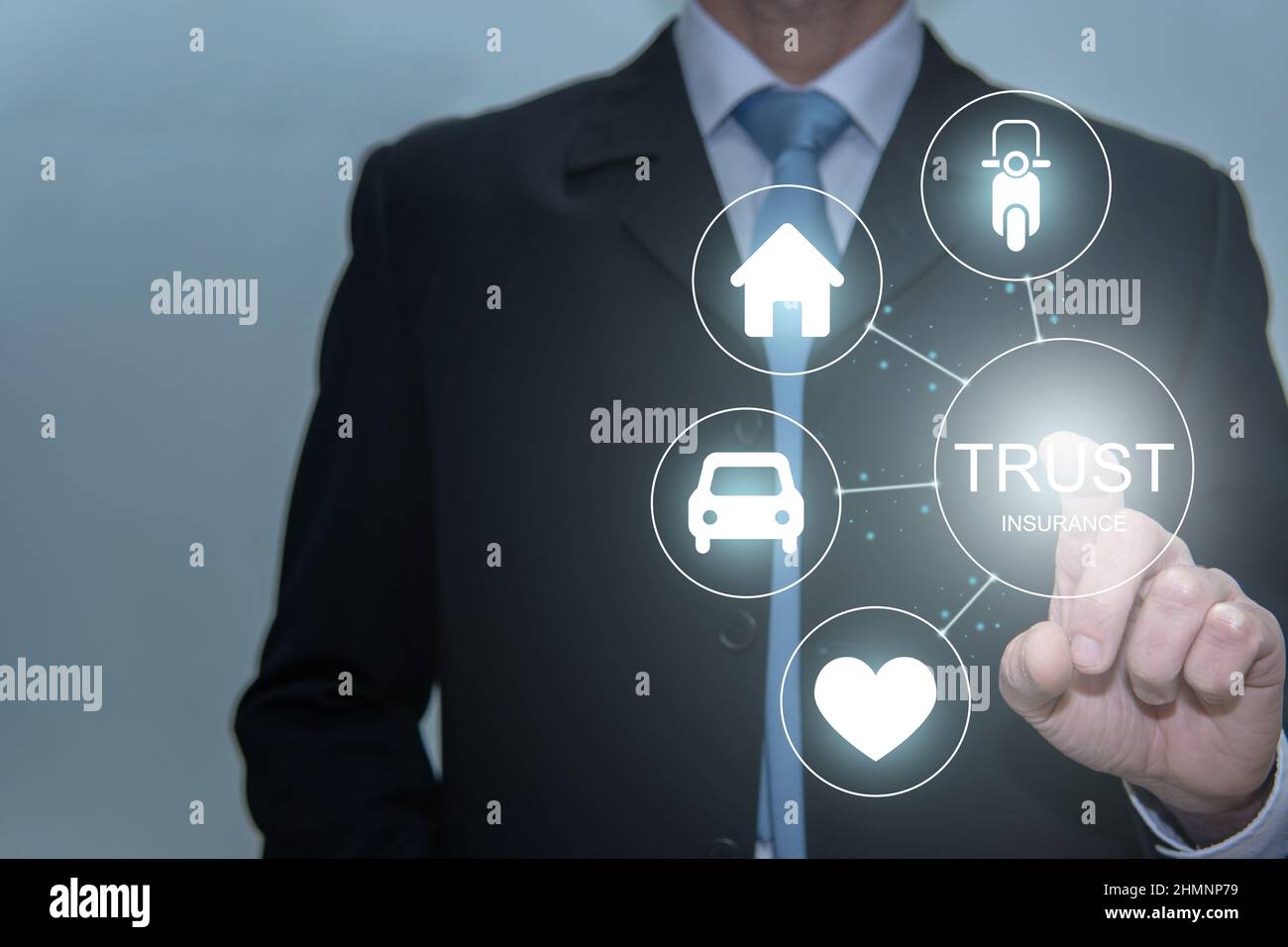 Geschäftsmann berührt Vertrauenssymbol. Leben, Haus, Auto und Motorrad Stockfoto