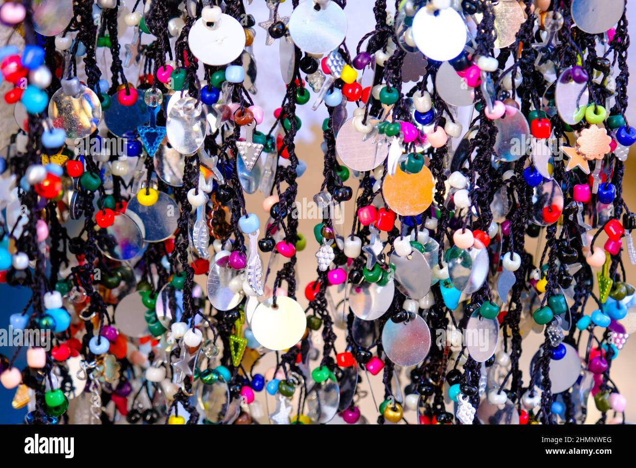 Bunte handgemachte ethnische Schmuck oder Armband Reize aufgereiht auf einem Seil Kleiderbügel in Frau Hersteller Basar in Odemis, Izmir. Viele moderne Accessoires Stockfoto