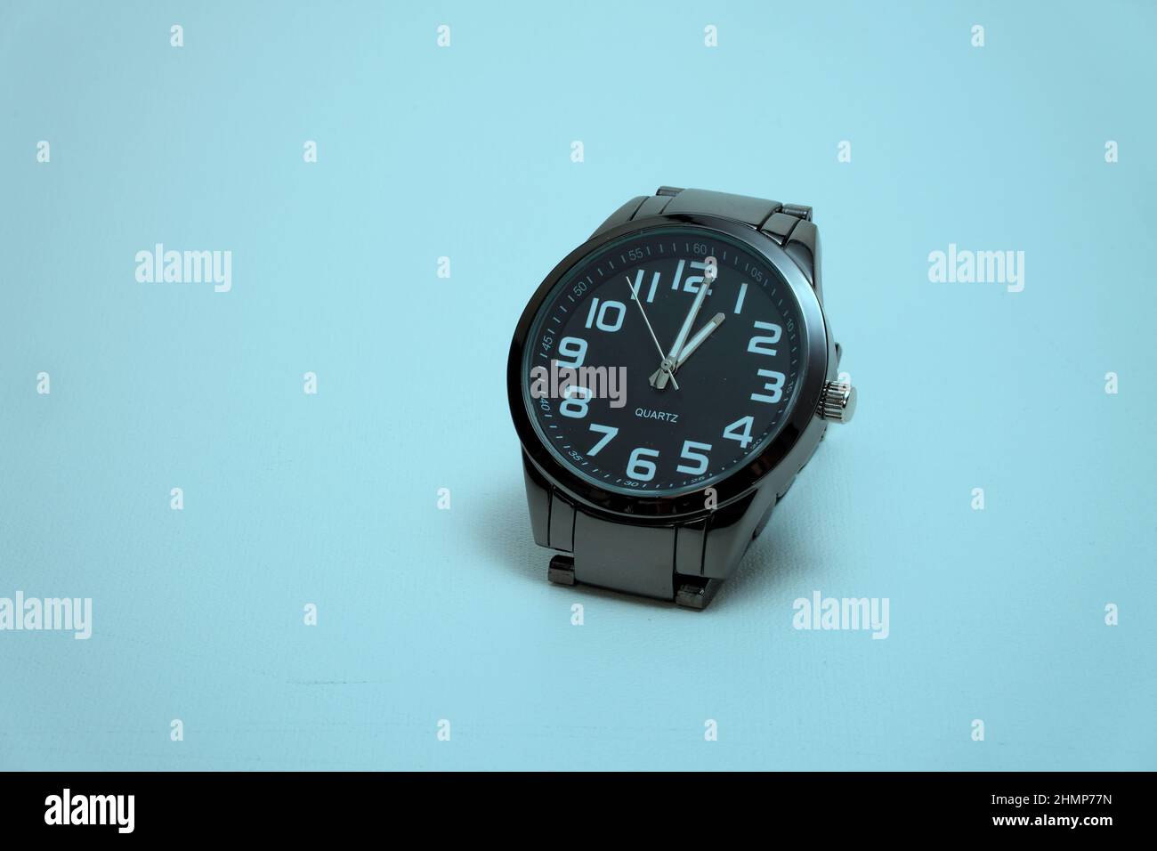 Schwarze Armbanduhr auf blauem Hintergrund Stockfoto