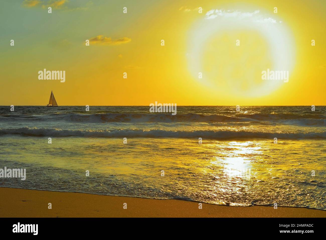 Goldene Seestücke mit großer Sonnenscheibe am Zenithand einer Yacht Stockfoto