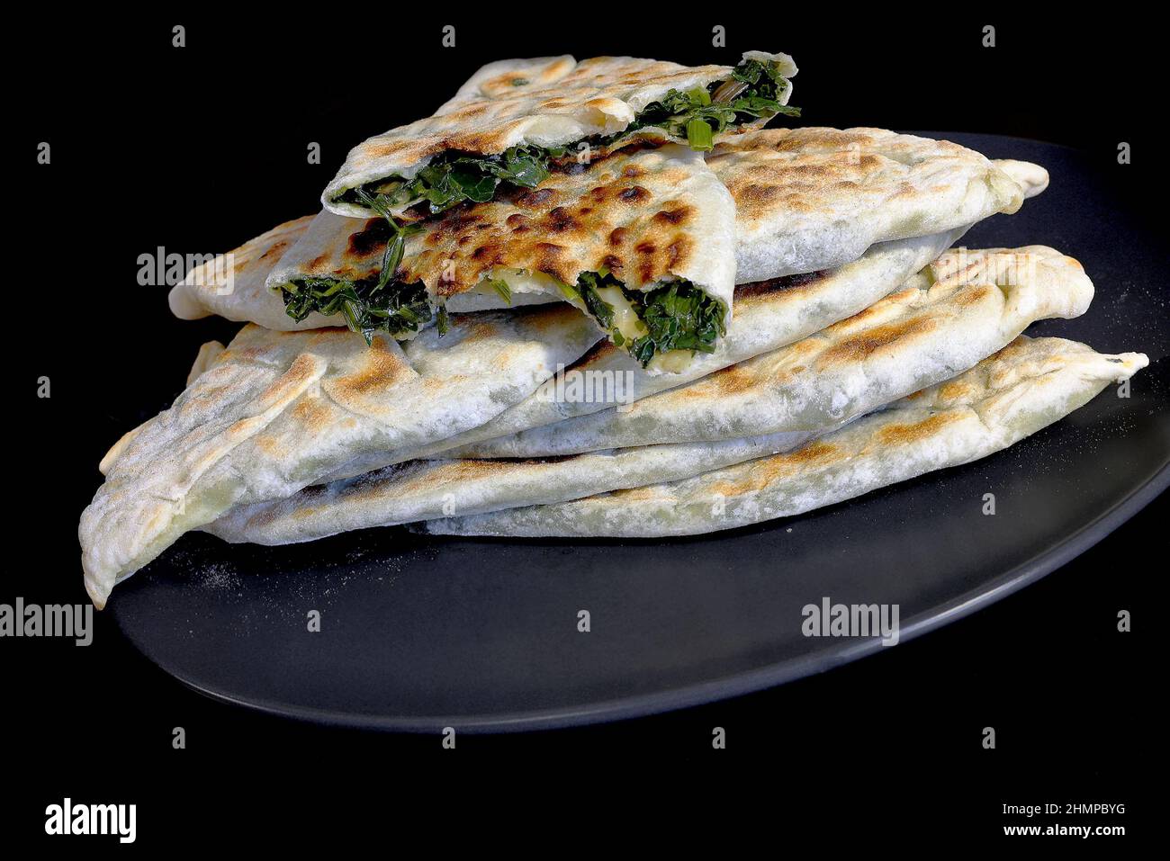 Backen traditioneller armenischer Gerichte - Zhengyal Brot. Brot mit verschiedenen Kräutern. Kreuzbruch von armenischem Zhengyal-Brot mit geringer Tiefe von f Stockfoto