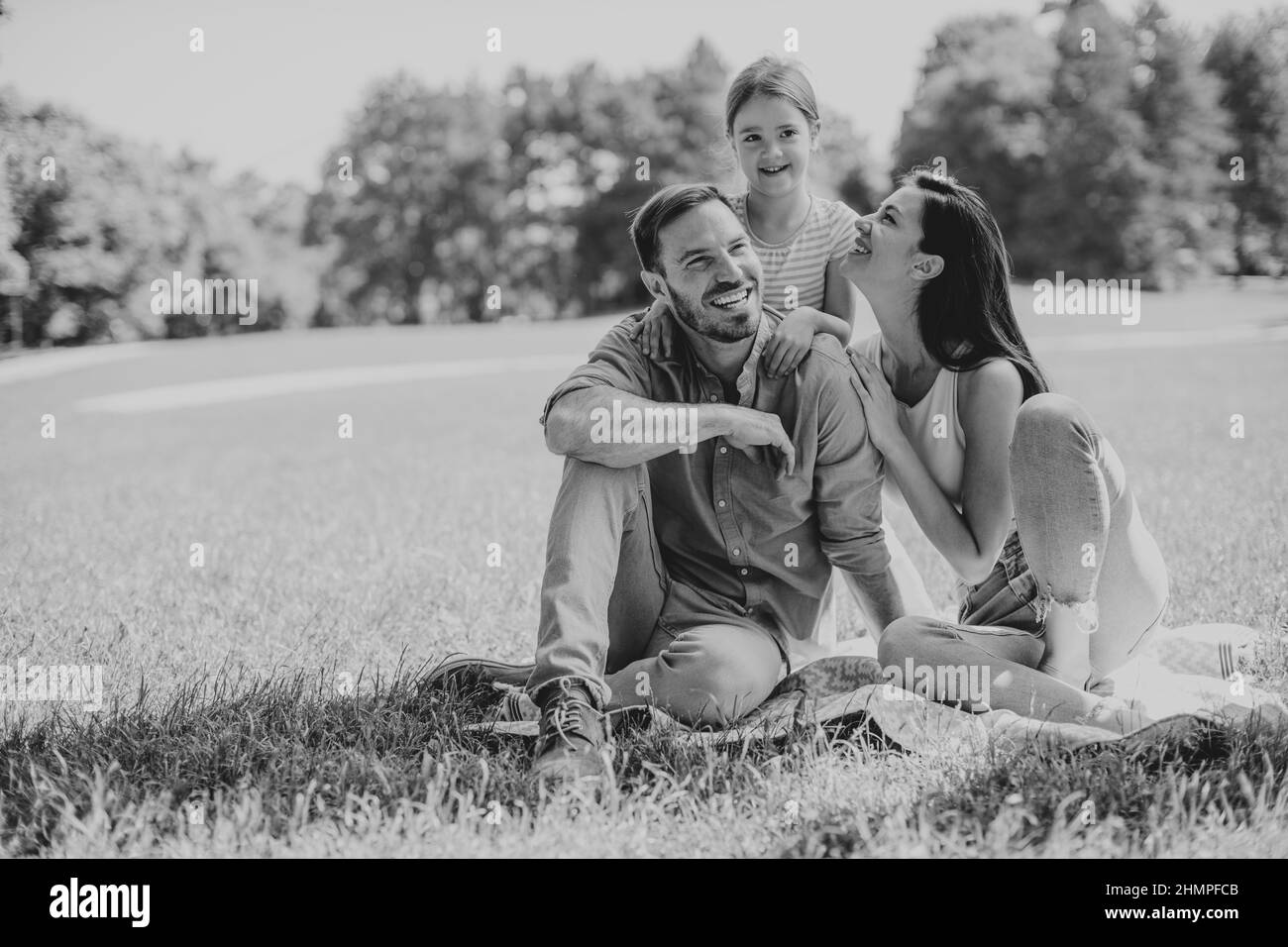Glückliche junge Familie mit niedlichen kleinen Tochter Spaß im Park an einem sonnigen Tag Stockfoto