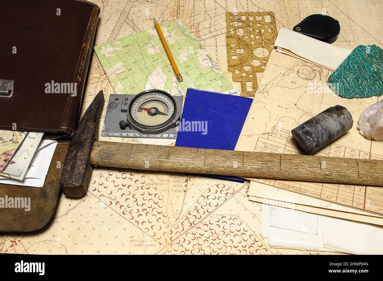 Geologische Feldforschungstools: Kartenkoffer, geologischer Hammer, Kompass, Lupe, Bohrkern, Gesteinsproben, topographische und geologische Karten Stockfoto