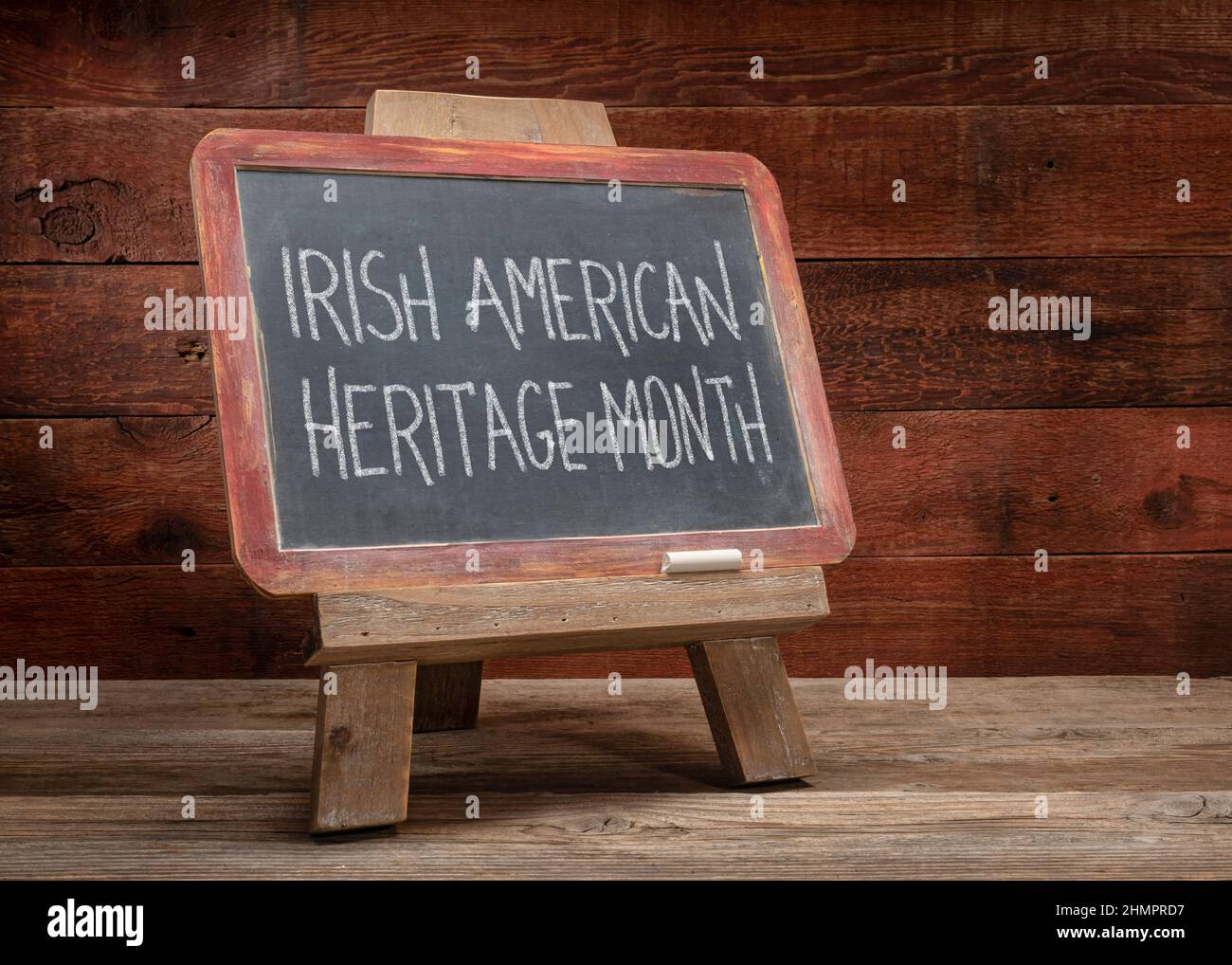 Irish American Heritage Month - weiße Kreide Handschrift auf einer Schiefertafel vor einem rustikalen verwitterten Holzhintergrund, Erinnerung und Bildung über Stockfoto