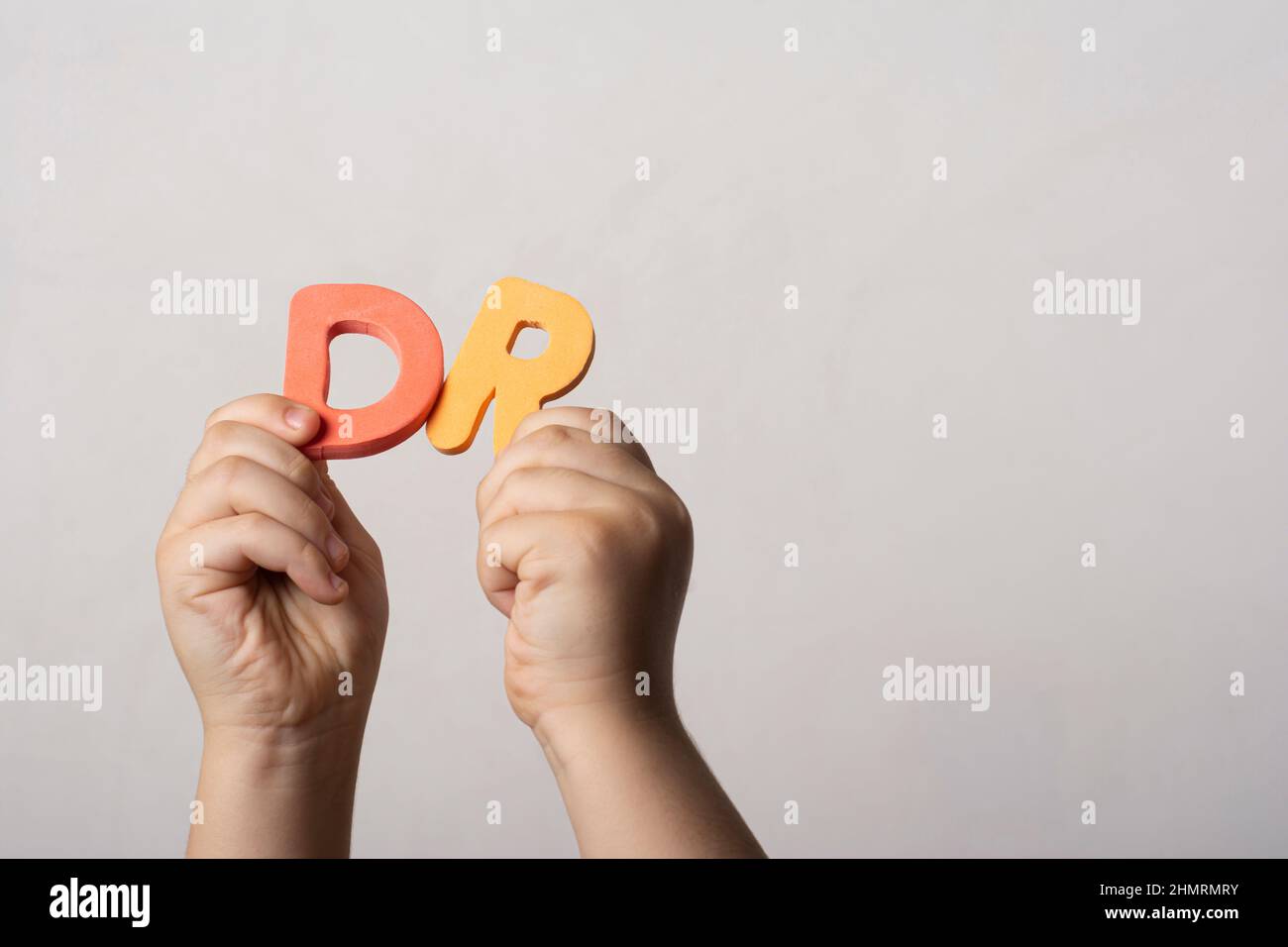 Hände, die zwei schwammige Buchstaben halten, blockieren das Wort DR (Abkürzung des Arztes) Stockfoto