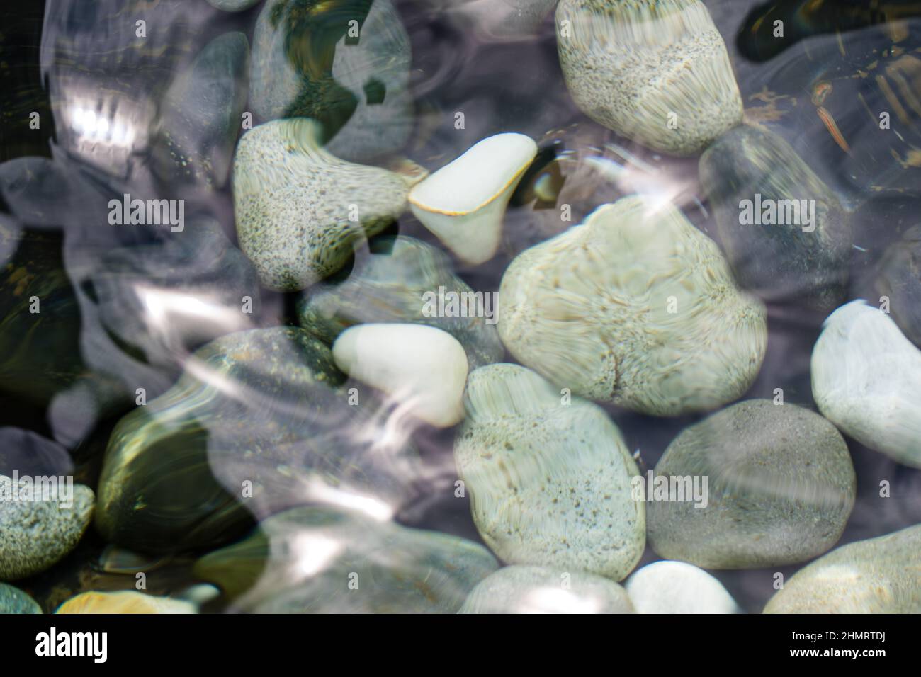 Blick auf die Kieselsteine im Wasser durch wackelnde Oberfläche Stockfoto