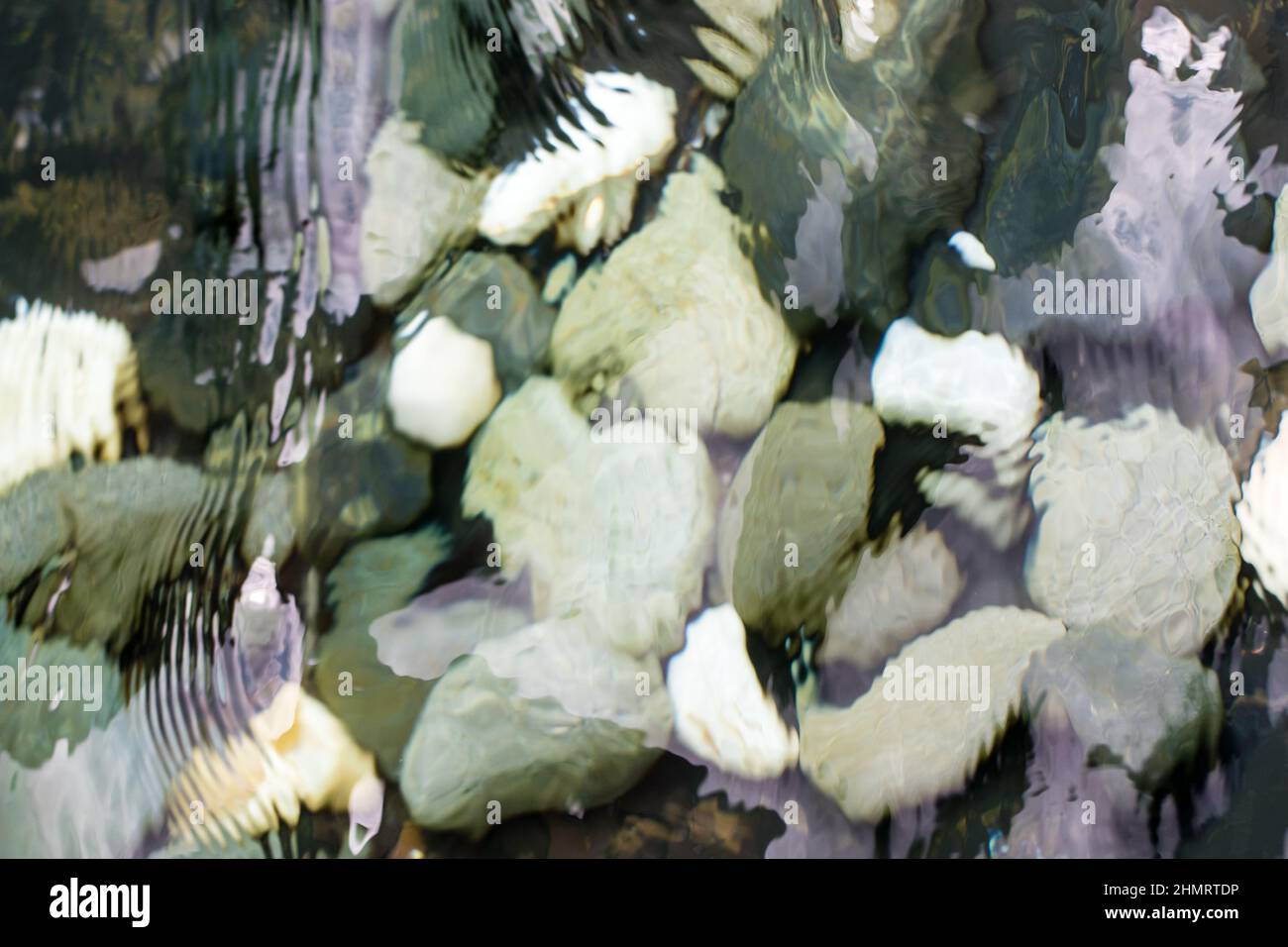 Blick auf die Kieselsteine im Wasser durch wackelnde Oberfläche Stockfoto