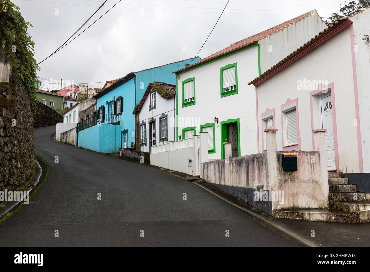 Schmale steile Straße mit bunten Häusern in einem kleinen Ort auf der Terceira Insel Azoren, Portgal Stockfoto
