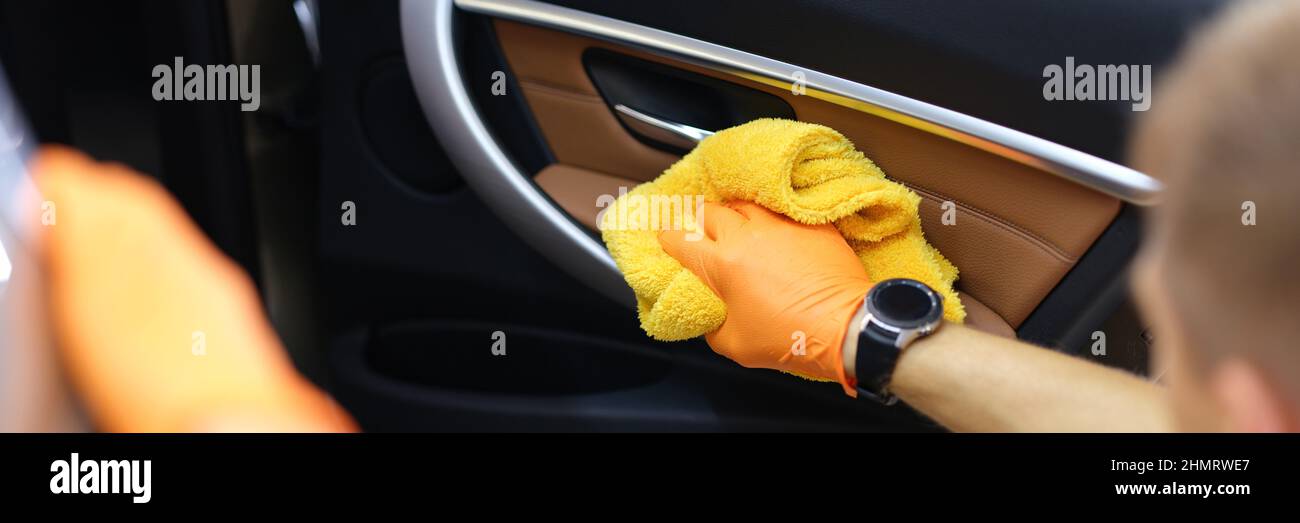 Der Handwerker mit Handschuhen wischt die Autotüren in der Kabine aus der Nähe ab Stockfoto