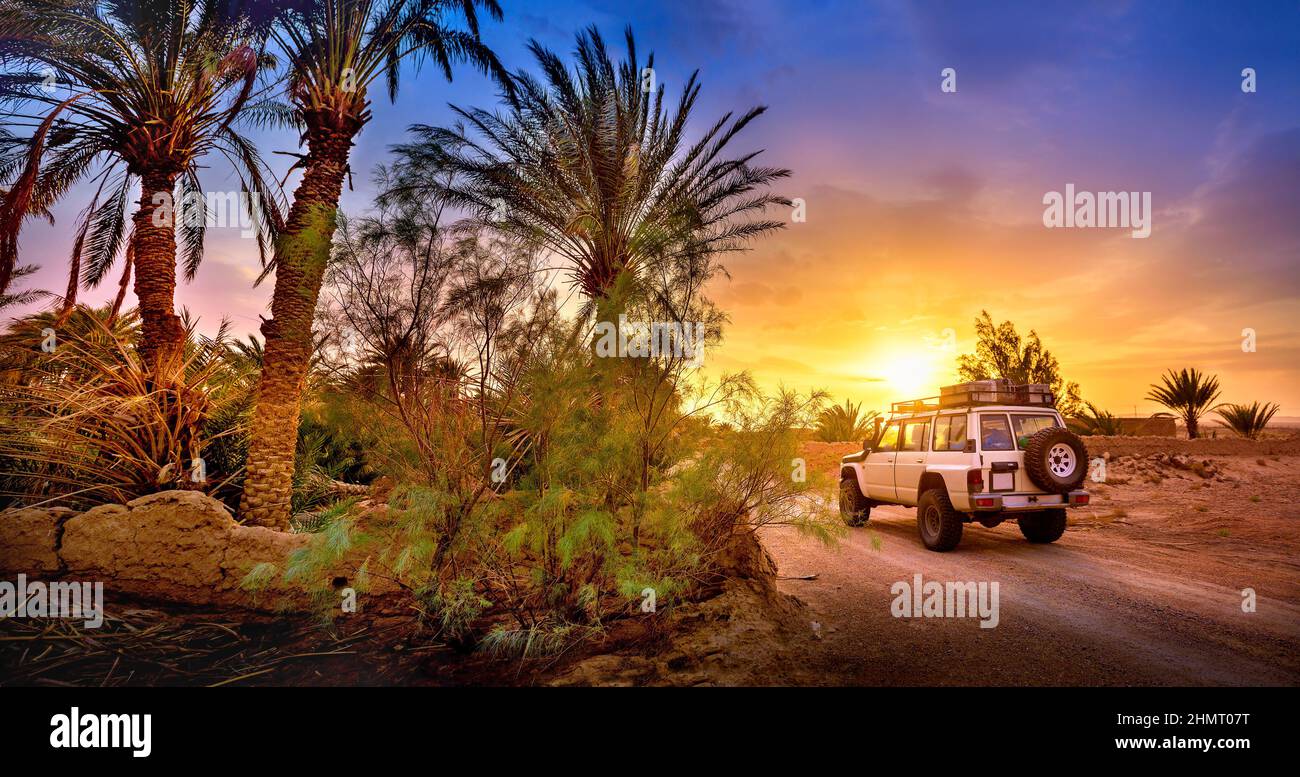 Reisen, SUV fährt eine Wüstenstraße bei schönem Sonnenuntergang, extreme Reise Abenteuer in der Natur Stockfoto