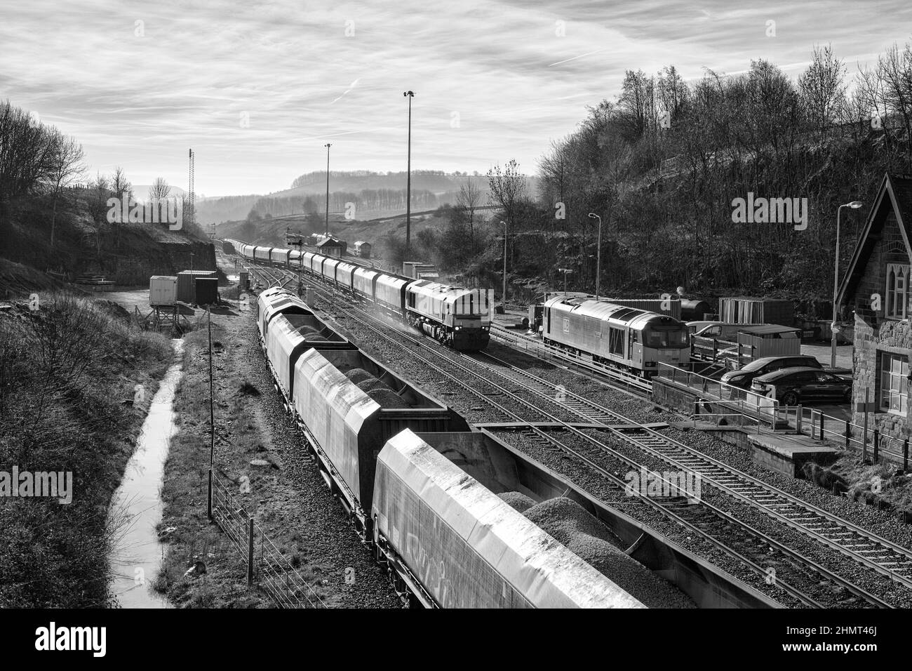 Güterzüge in Peak Forest, Derbyshire, mit einer Lokomotive der Baureihe 66 der GB Railfright, die mit einem schweren Zuschlagzug abfährt, wobei die Sanders arbeiten Stockfoto
