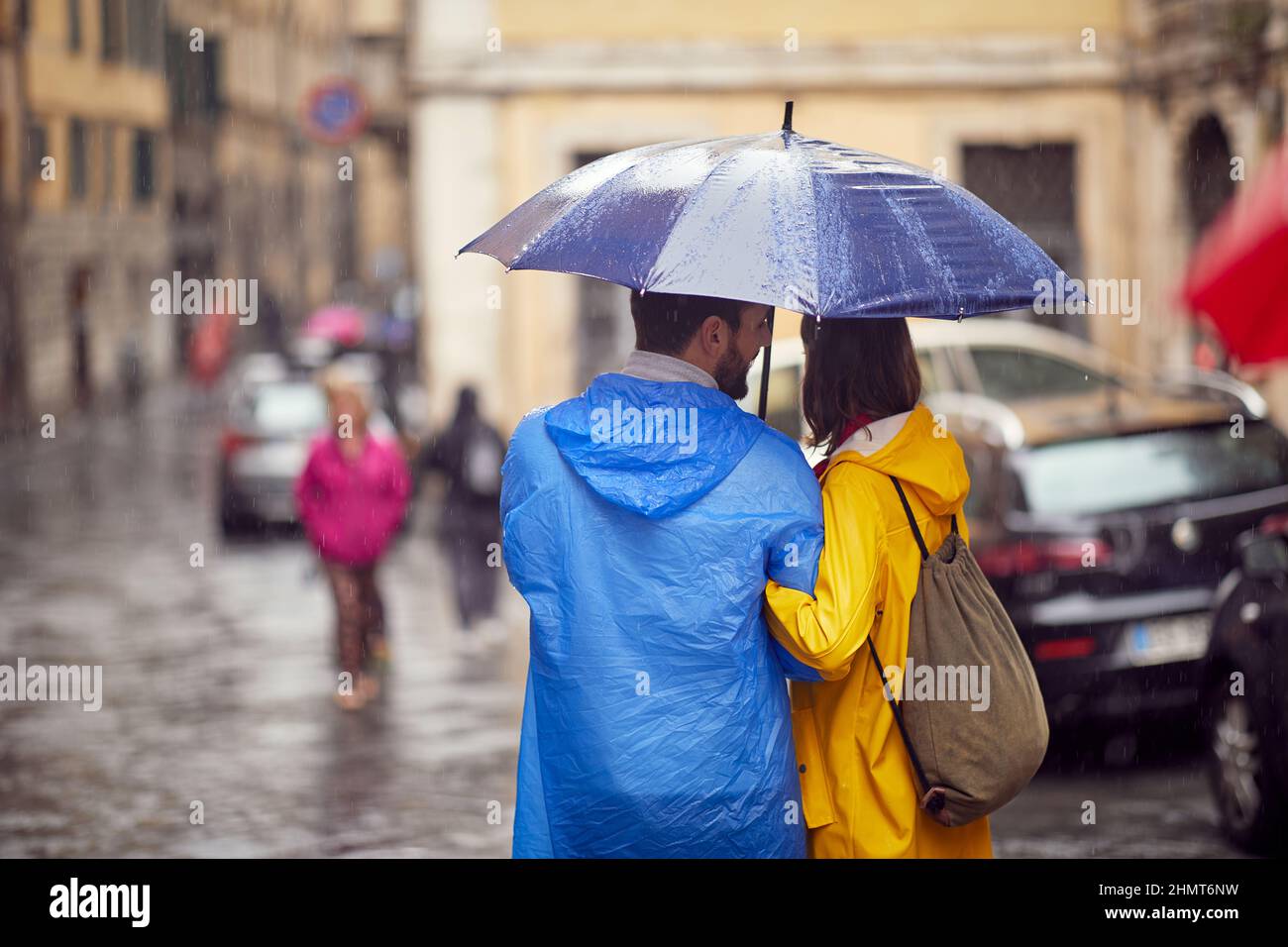 Aufgenommen von einem verliebten jungen Paar, das an einem regnerischen Tag entspannt durch die Stadt läuft. Gehen, Regen, Stadt, Beziehung Stockfoto