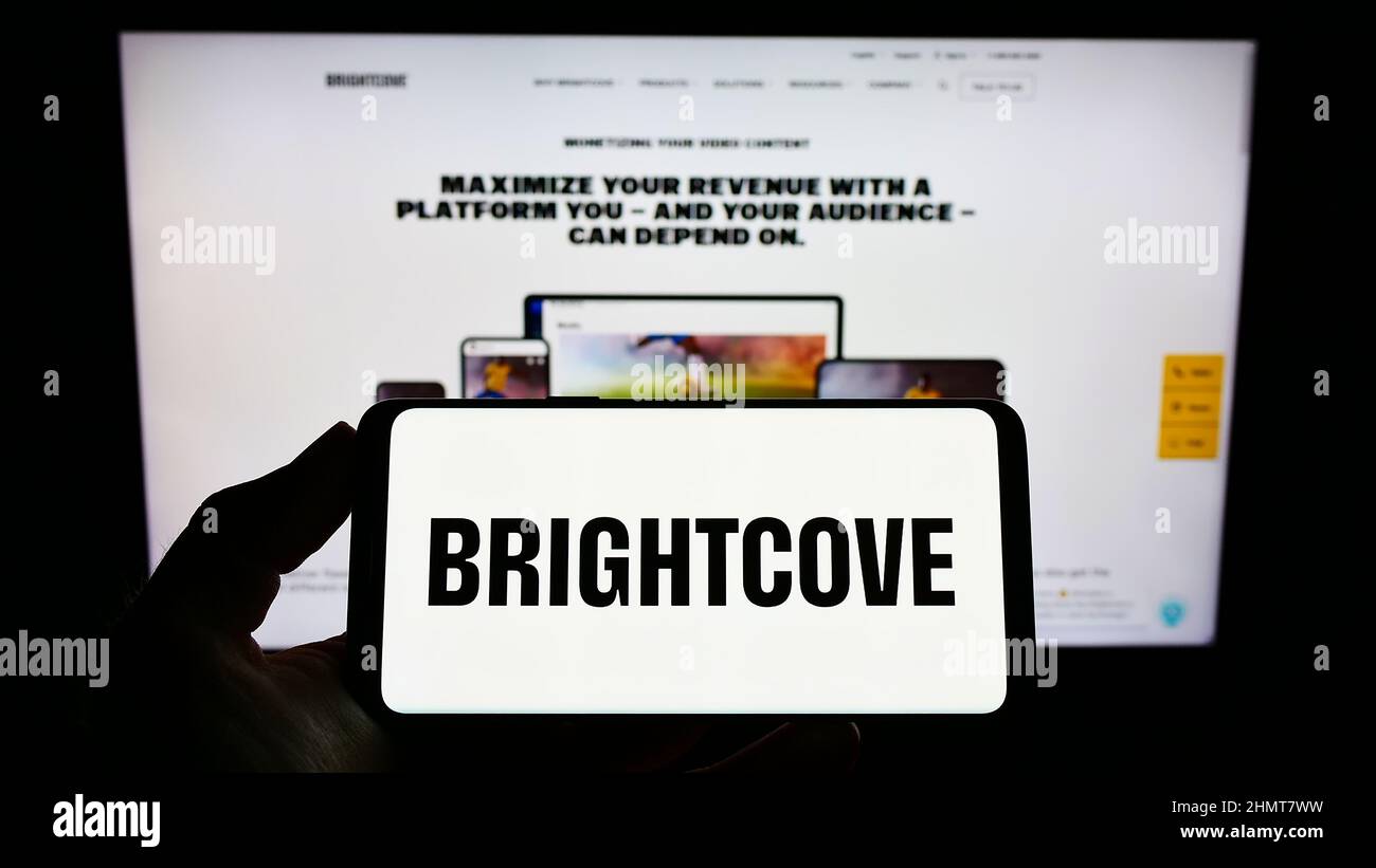 Person, die das Smartphone mit dem Logo des US-amerikanischen Videoplattform-Unternehmens Brightcove Inc. Auf dem Bildschirm vor der Website hält. Konzentrieren Sie sich auf die Telefonanzeige. Stockfoto