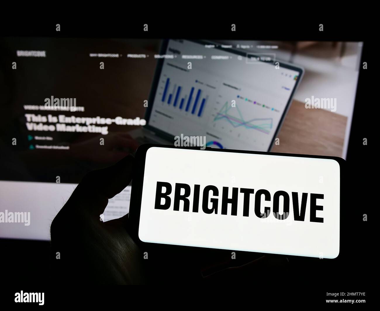 Person, die ein Mobiltelefon mit dem Logo des US-amerikanischen Videoplattform-Unternehmens Brightcove Inc. Auf dem Bildschirm vor der Unternehmenswebseite hält. Konzentrieren Sie sich auf die Telefonanzeige. Stockfoto