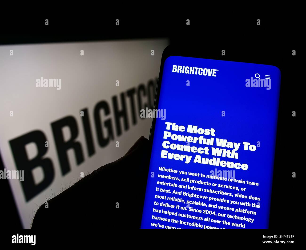 Person, die ein Mobiltelefon mit der Website des US-amerikanischen Videoplattform-Unternehmens Brightcove Inc. Auf dem Bildschirm vor dem Logo hält. Konzentrieren Sie sich auf die Mitte des Telefondisplays. Stockfoto