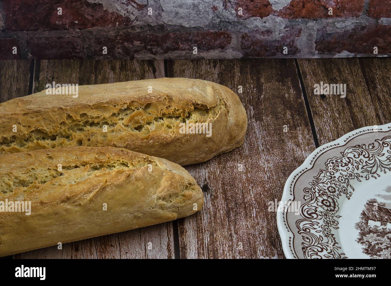 Hausgemachtes Brot auf Holztisch. Szene mit rustikalem Ambiente mit Vintage-Holztisch, hausgemachtem Brot und Vintage-Gericht. Stockfoto