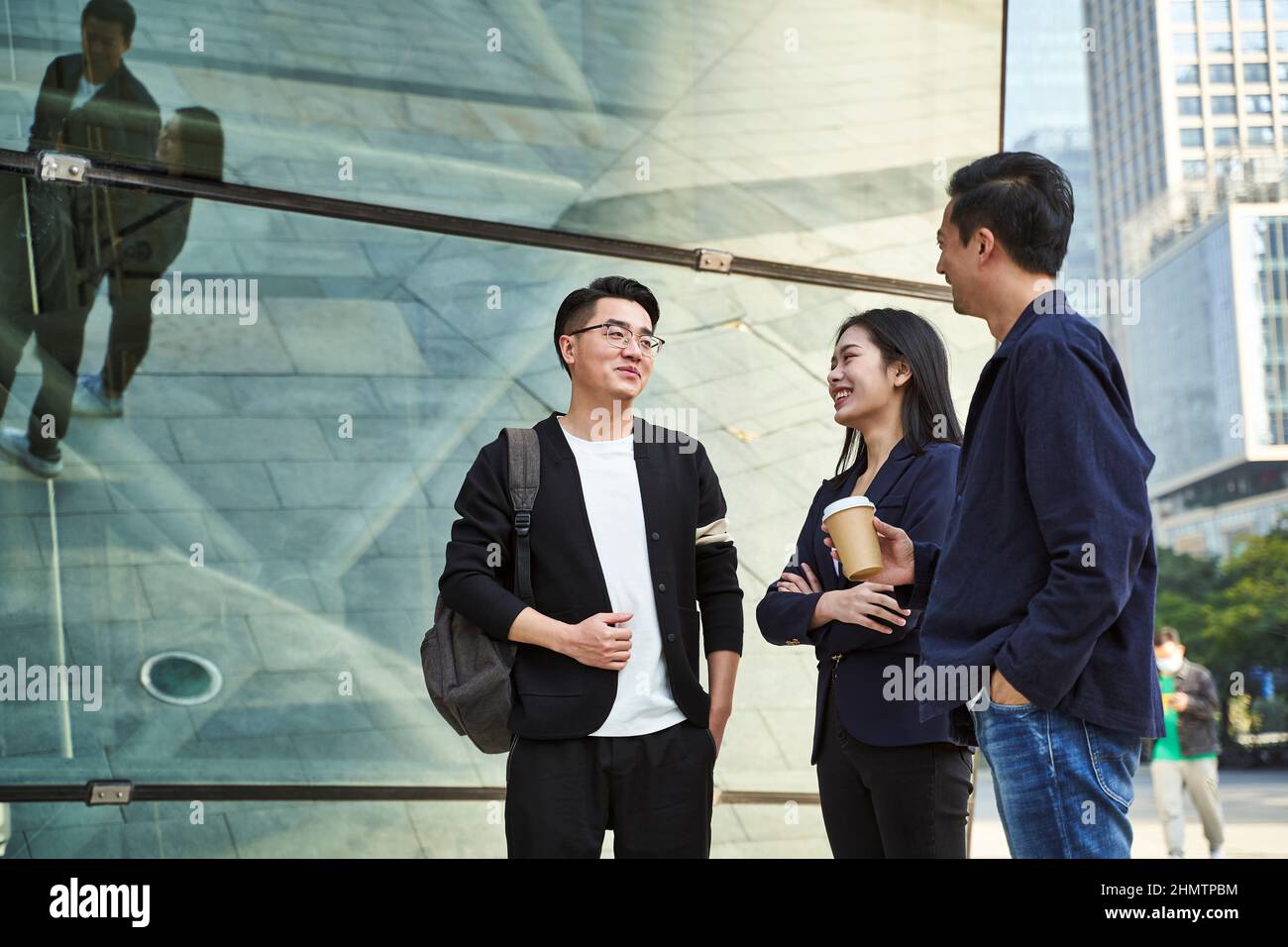 Junge asiatische Menschen stehen auf der Straße und sprechen glücklich und lächelnd Stockfoto