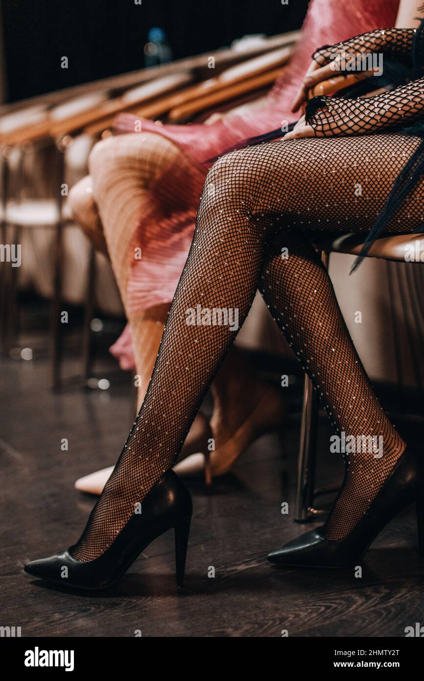 Schlanke weibliche Beine in eleganten Netzstrumpfhosen und schwarzen High Heel Schuhen Stockfoto